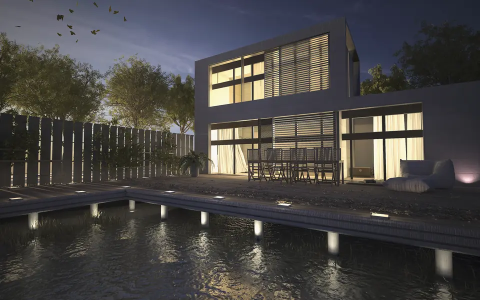 Stille concept visual: a concrete and glass villa with warmly lit rooms behind a long reflecting pool at dusk
